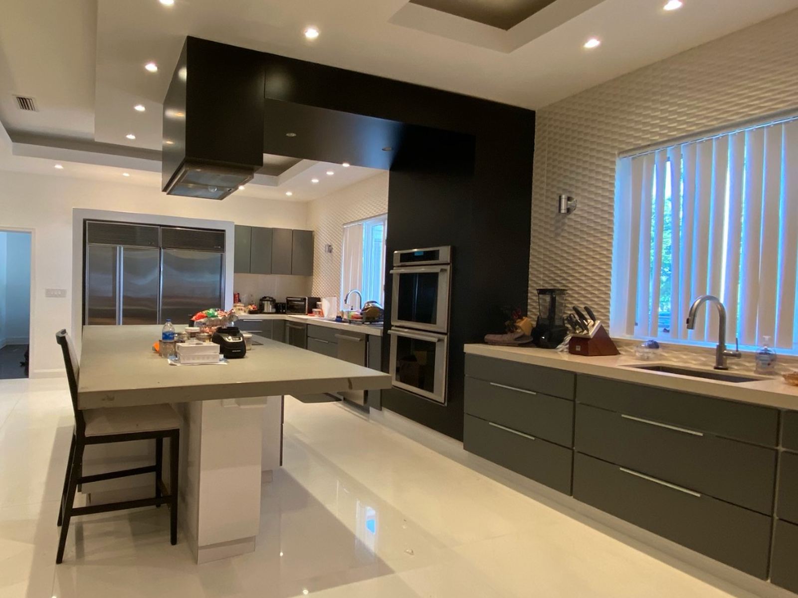 The same kitchen after resurfacing, cabinets hood and oven surround in matte charcoal