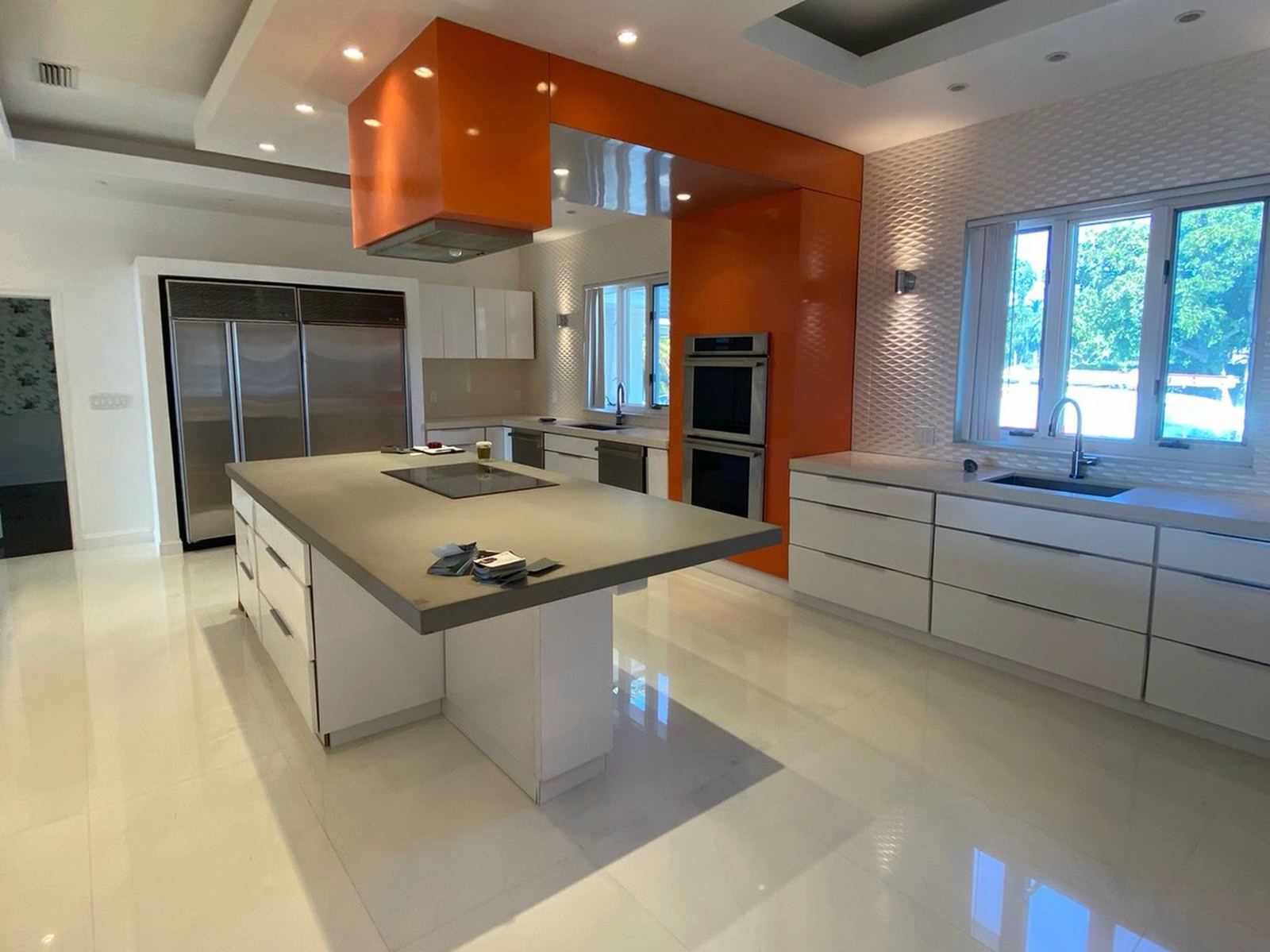 Kitchen before resurfacing, gloss white cabinets with an orange hood and oven surround
