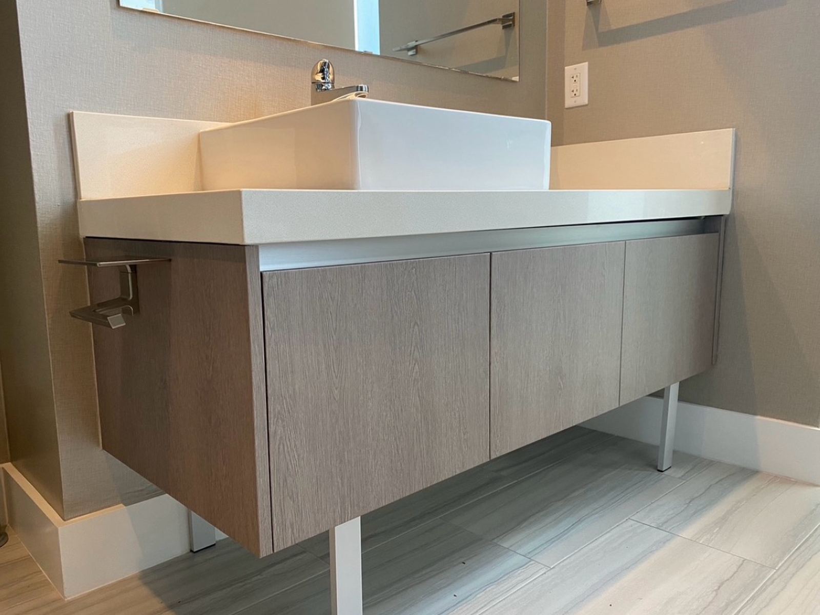 The same floating vanity after resurfacing, weathered grey oak doors