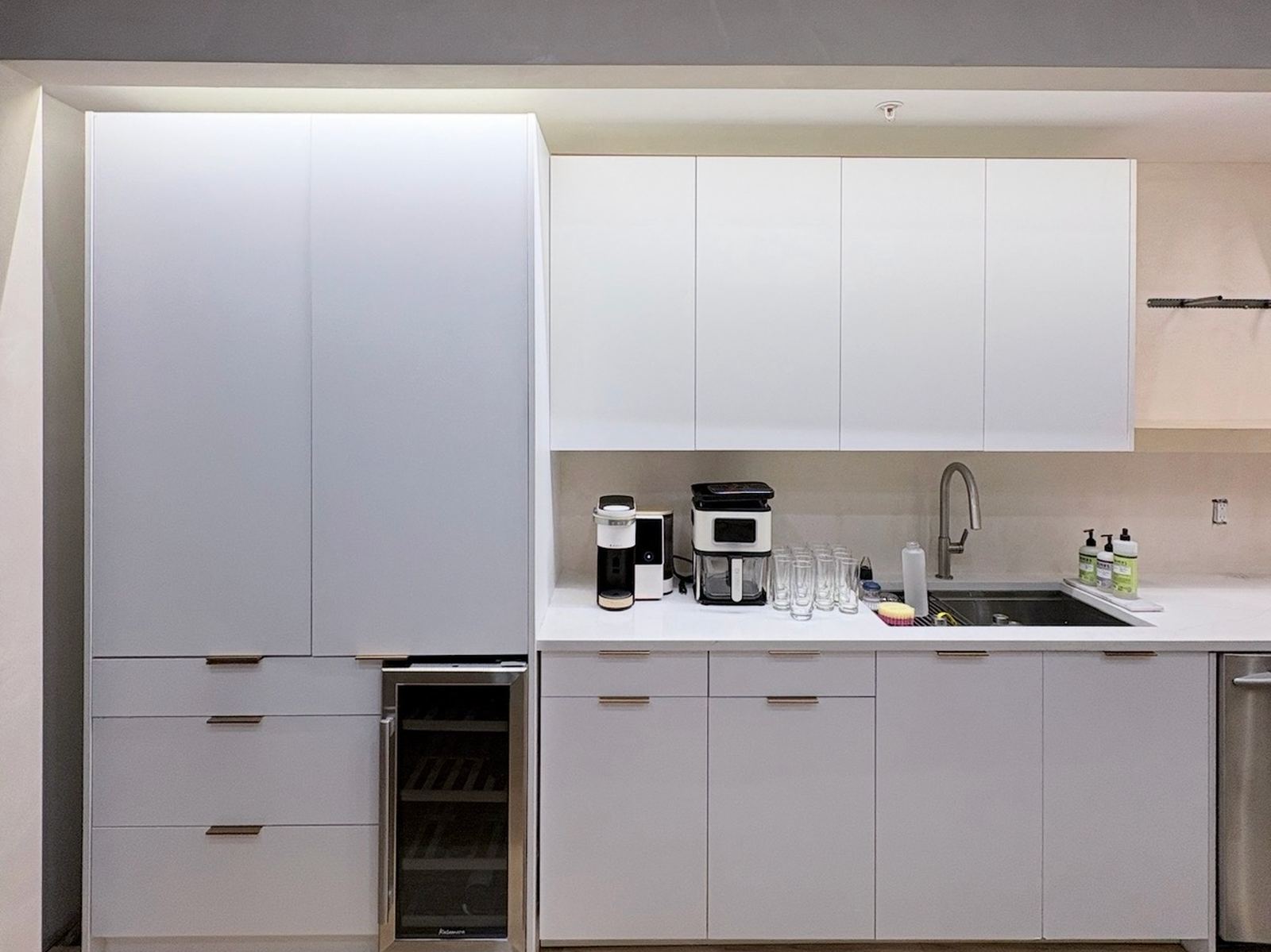 The same pantry before resurfacing, flat white cabinet fronts